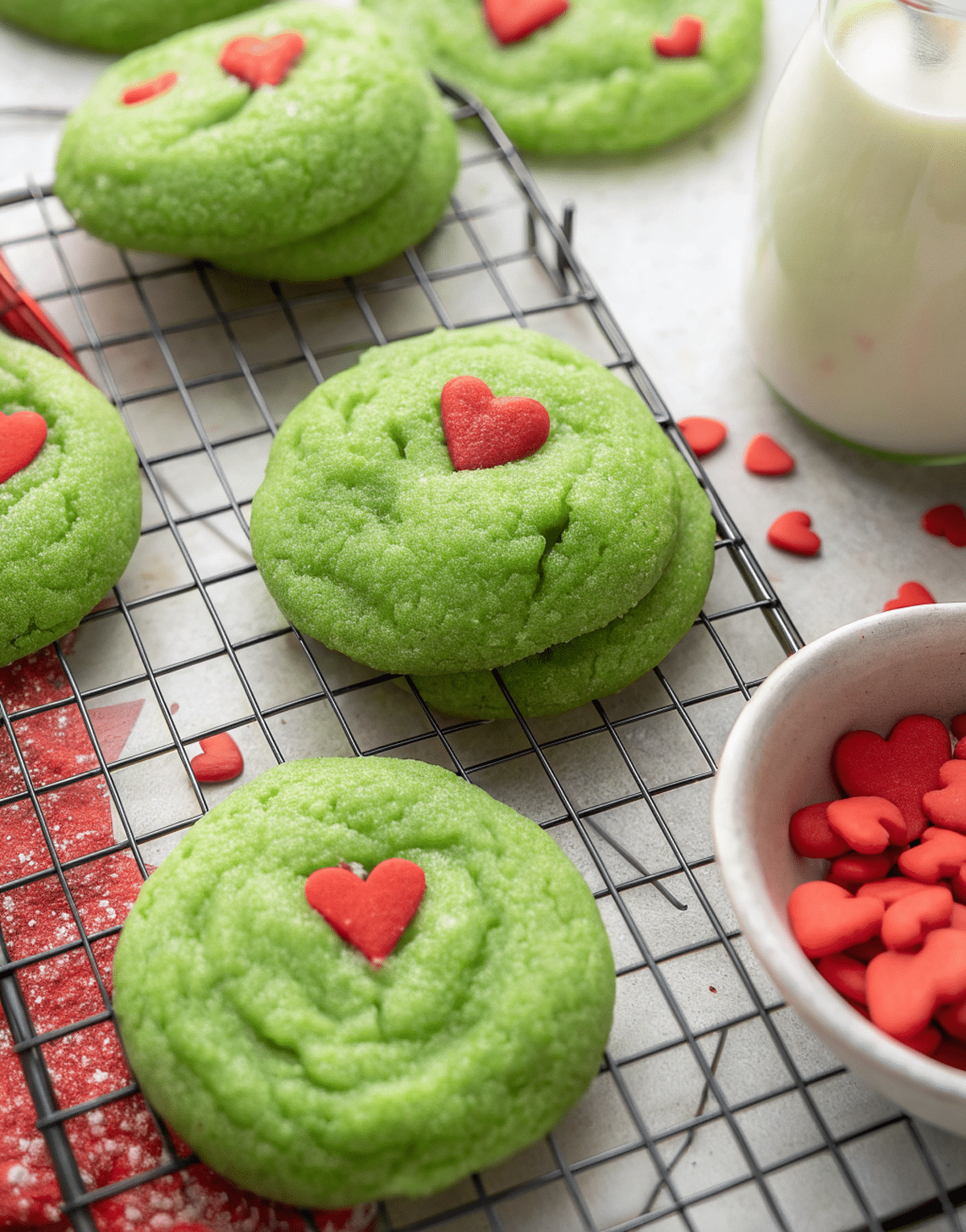 person serving Grinch sugar cookies in bright kitchen