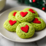 freshly baked green Grinch sugar cookies with red hearts